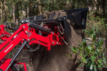Mahindra 422 tractor loading dirt with a red hydraulic loader, ideal for heavy-duty landscaping tasks.