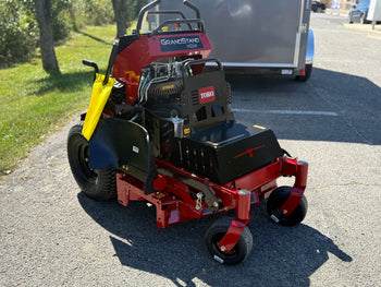 Toro GrandStand HDX mower, red and black, features durable construction and enhanced maneuverability for landscaping.