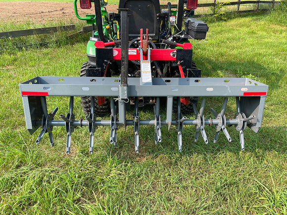 Heavy-duty grey cultivator attachment for tractors, featuring multiple tines for effective tilling.